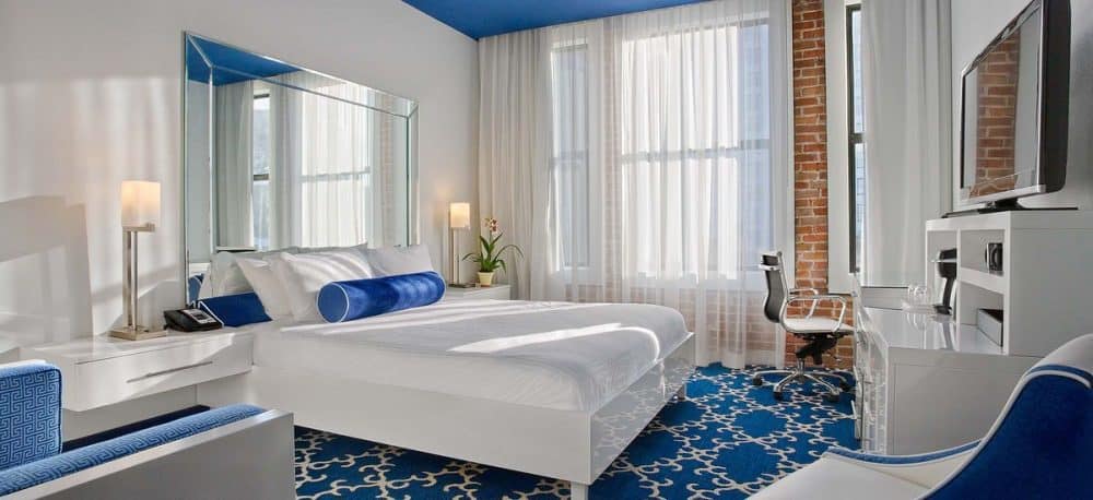 A bedroom with a bed and a window in The Saint Hotel in the New Orleans