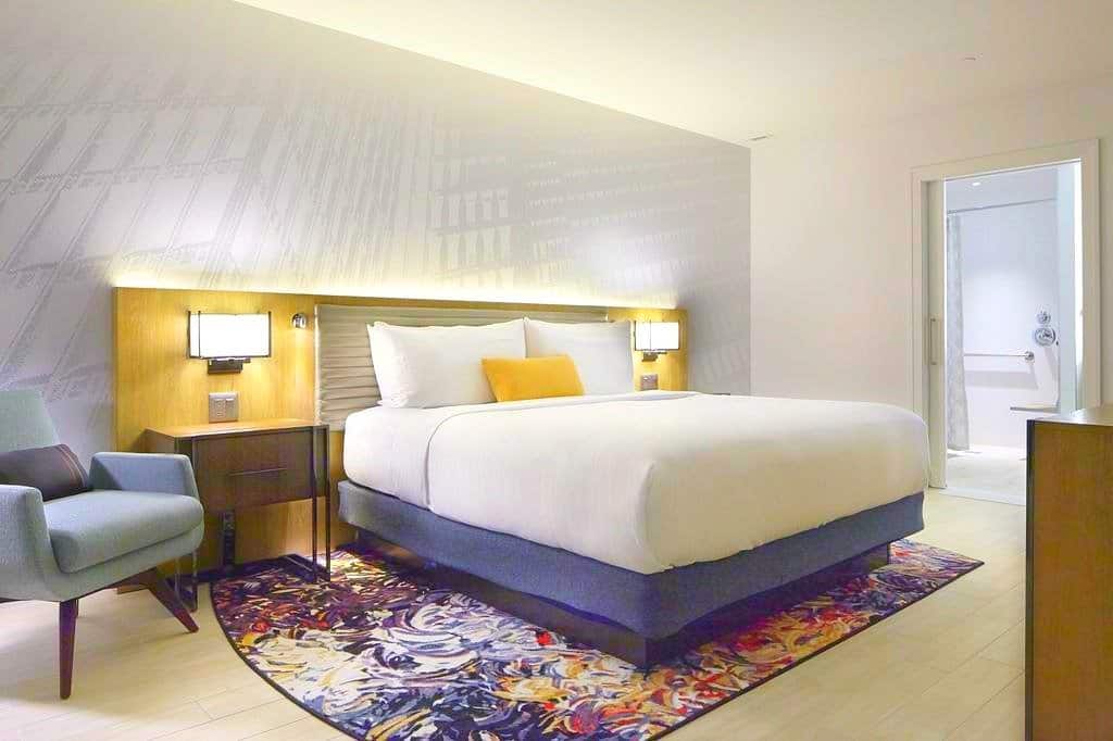 A bedroom with a bed and desk in a room Hotel Indigo Atlanta